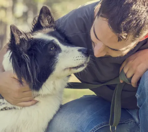 Dog with a man bending down giving him a kiss